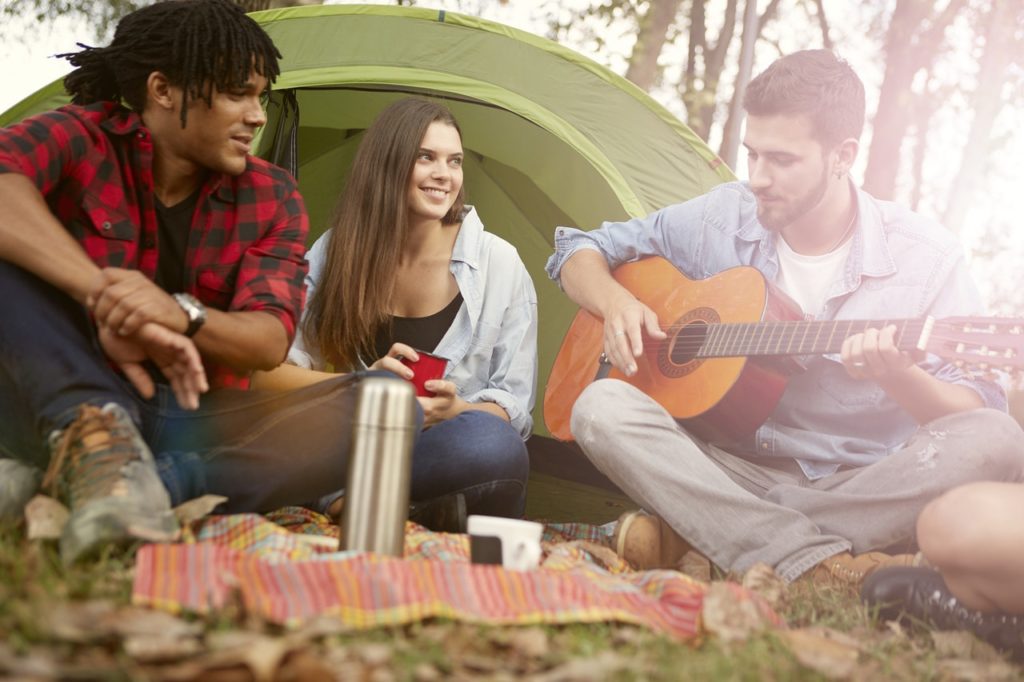 friends camping and playing guitar