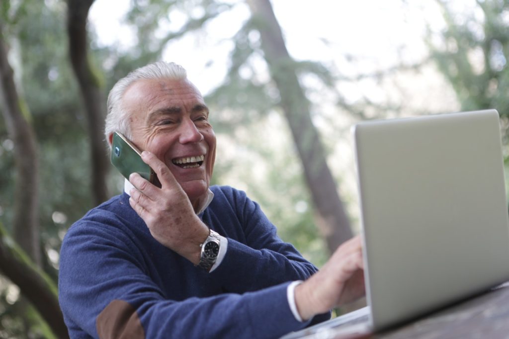 older man on cellphone in the forest